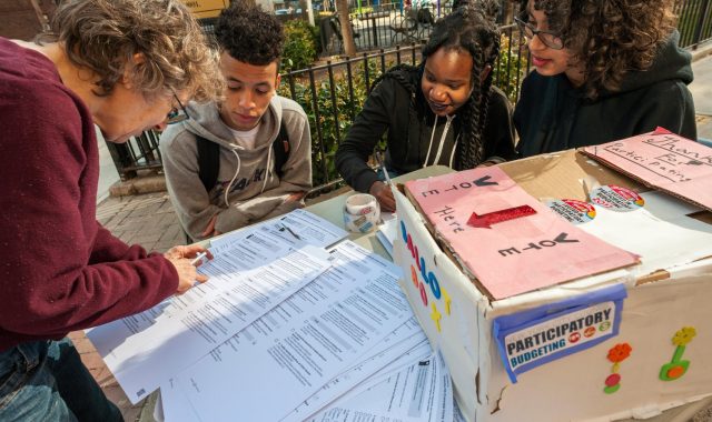A resident of city Council District 3, left, in New York casts her ballot in participatory budgeting on Sunday, April 2, 2017. Voters residing in some of the City Council districts that are participating can choose projects to receive the largesse of each district's $1 million capital budget. (© Richard B. Levine)
